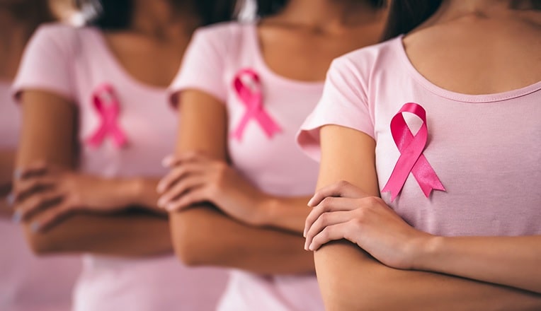 femmes qui portent un t-shirt rose avec le logo de la lutte contre le cancer