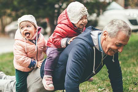 grand-père jouant avec ses petits enfants
