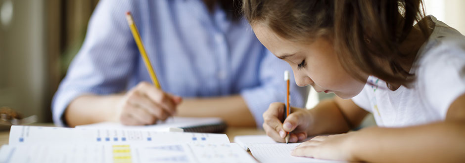 enfant qui fait ses devoirs de vacances avec sa mère
