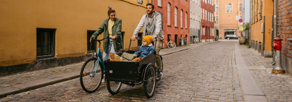 famille avec enfant se déplaçant en ville en vélo cargo