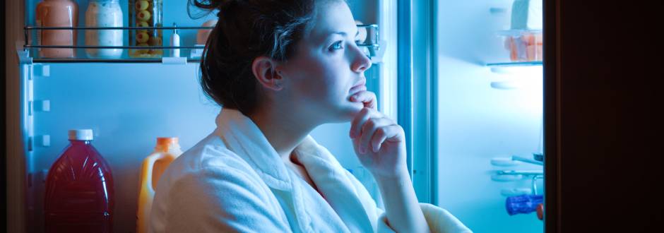 femme regardant l’intérieur de son frigo en pleine nuit
