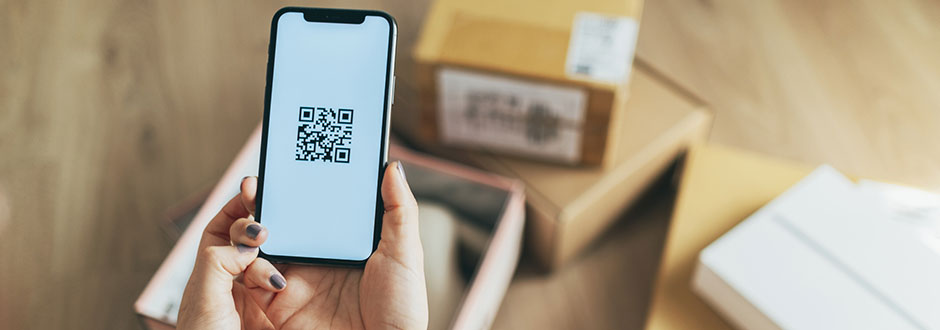 QR code de retour Amazon affiché sur un smartphone devant des colis