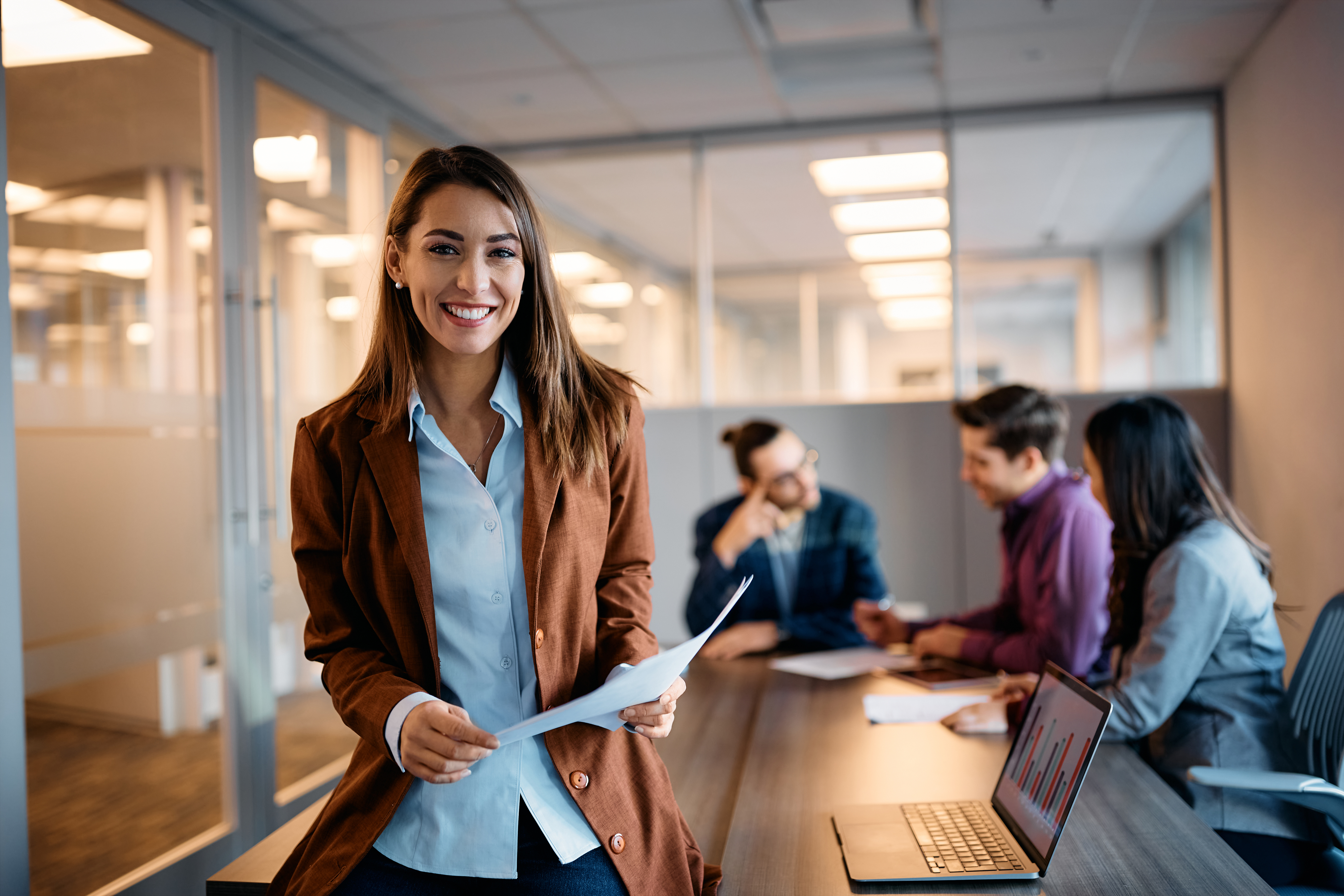 Femme devant une table avec groupe de travail au entour