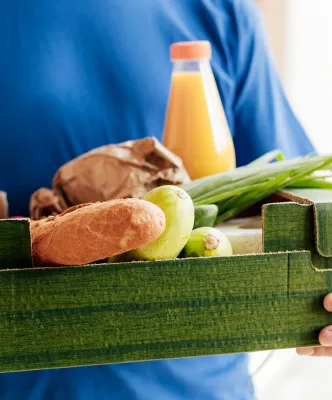 Photo illustrative d'un homme portant un panier de légumes
