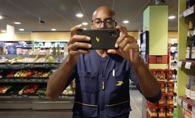 Photo d'illustration d'un facteur recensant les prix en magasin pour l'offre "Collecte d'informations"