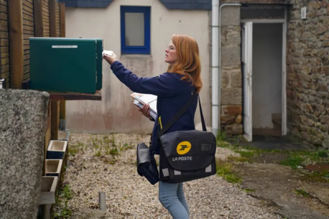 Postiere avec une boîte aux lettres