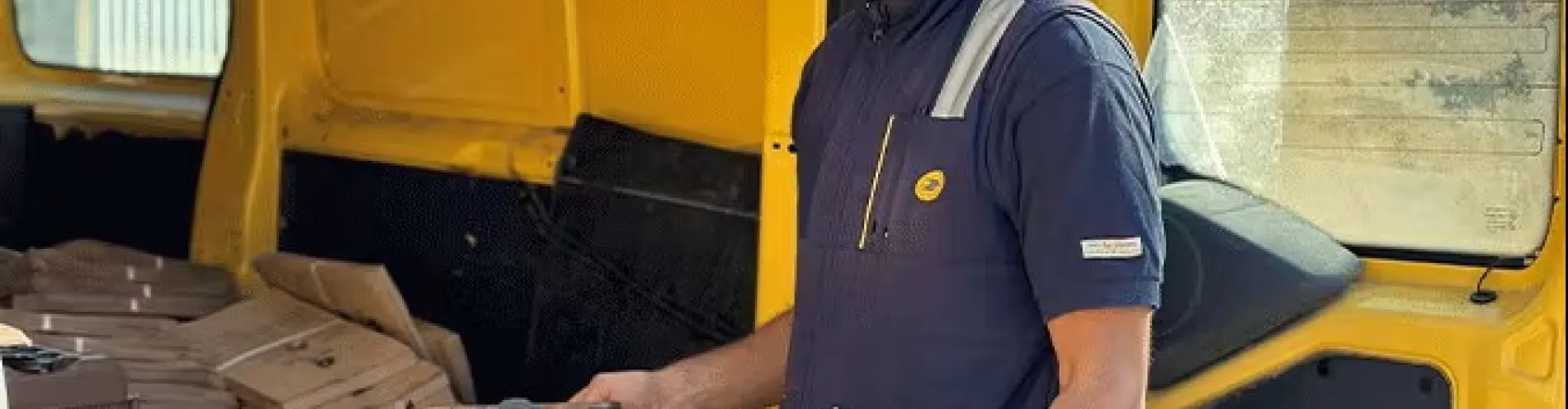 Facteur prend documents et bacs de tri biodéchets dans sa voiture jaune La Poste Solutions Business