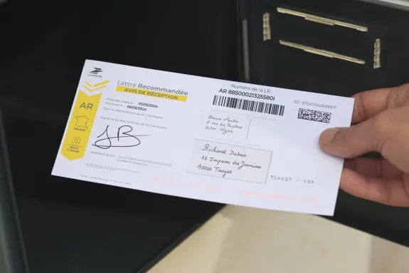 Homme mettant une ar dans une boîte au lettre 