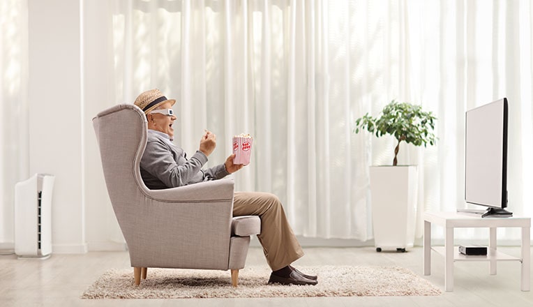 photo d'un homme qui regarde un écran avec du pop-corn et des lunettes 3D
