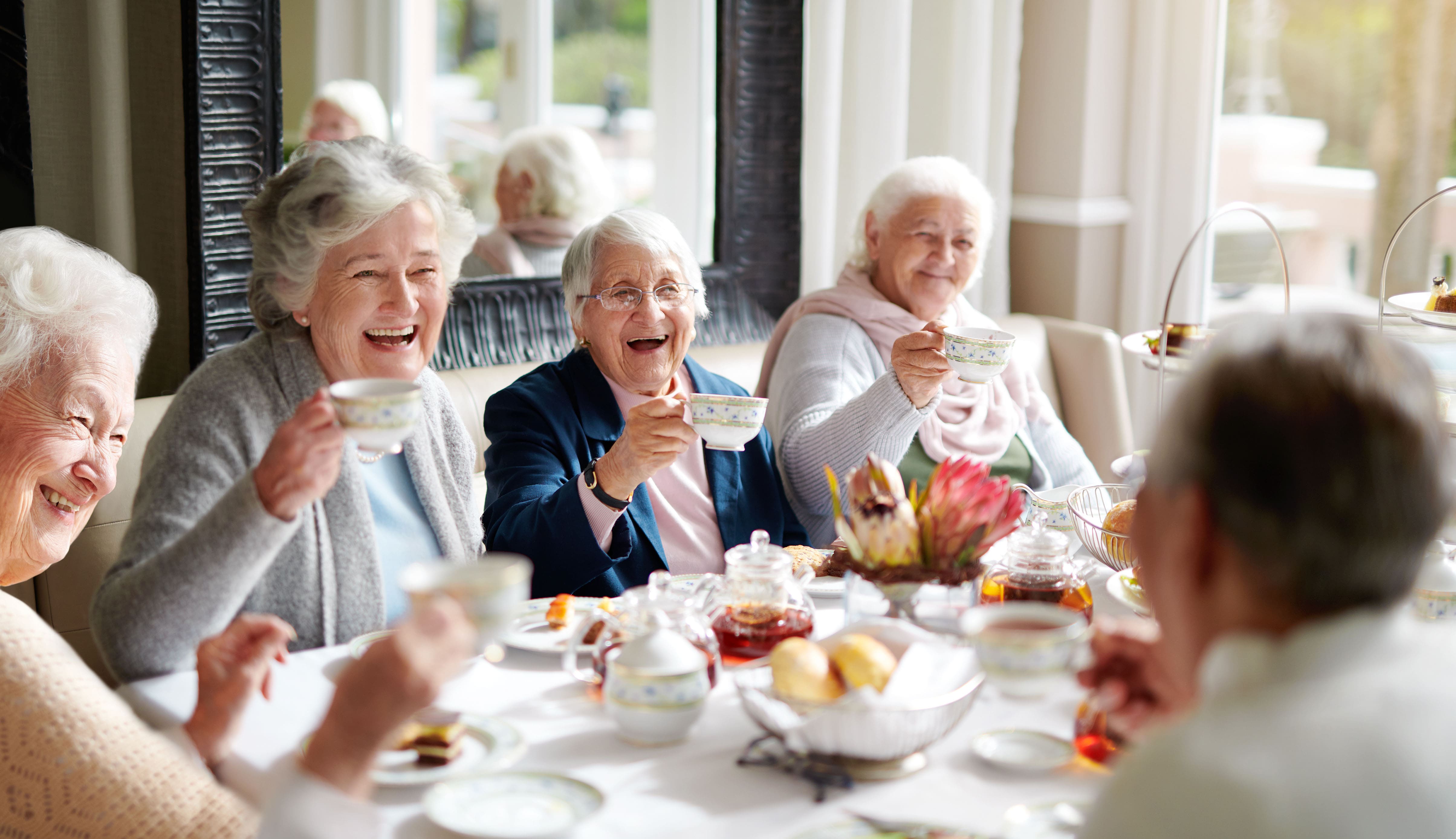 personnes âgées qui rigolent autour d'une table